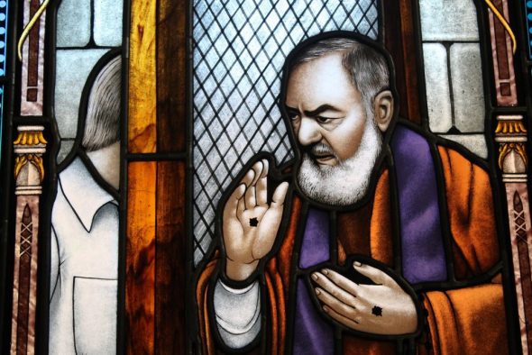 Le padre Pio confessant